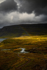A faint rainbow and a stormy sky above Arnarfjörður, near the Dynjandi waterfall, Westfjords,...