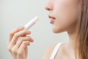 Lip care protection concept, pretty asian young woman, girl hand applying lipstick balm with...