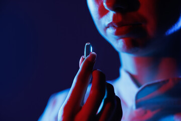 pill or drug close-up in hand near mouth in ultraviolet light