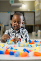 portrait of black little child playing with colored block