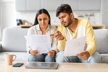 Indian Man and Woman Reviewing Papers on Couch