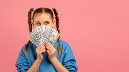 Curious girl looking at fan of money