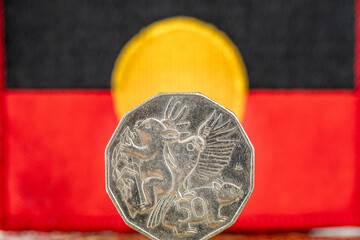 Aboriginal flag with 50 Australian cents coin, Concept, situation of the indigenous people of Australia - obrazy, fototapety, plakaty
