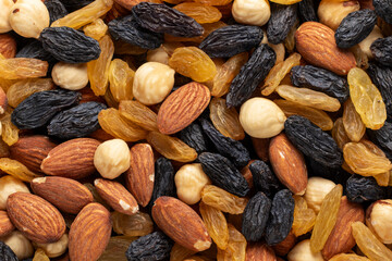 Mix of almonds, hazelnuts, golden and black raisins. Close-up, top view.