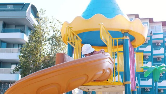 A child slides down a large spiral slide. Playground