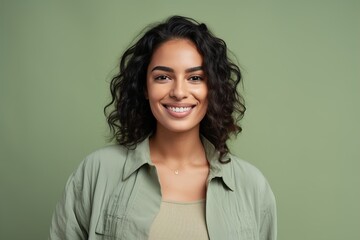 A woman with curly hair is smiling and wearing a green shirt