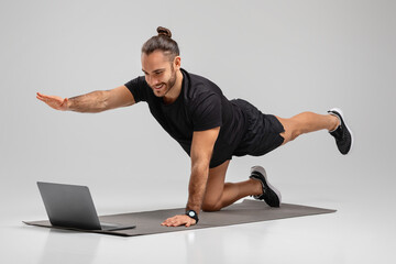 Man in plank position facing a laptop