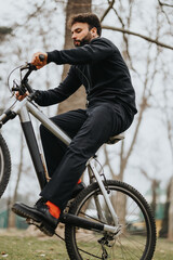 Active adult man cycling on a mountain bike through a serene park, with fallen leaves and bare trees signaling the autumn season.