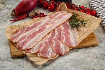 Sliced pork bacon over board