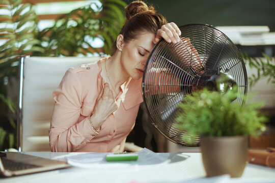 40 years old business woman at work suffer from heat