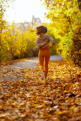 stylish woman in fitness clothes in park running