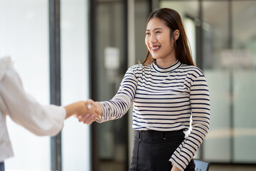 Two professionals engaging in a firm handshake, signifying a successful business agreement or...
