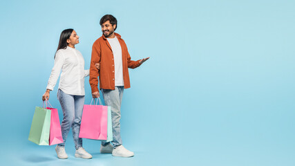 Couple with shopping bags looking at each other