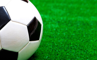 Classic soccer ball on artificial green grass - obrazy, fototapety, plakaty
