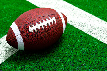 American football ball on field with white line