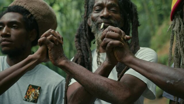 Closeup of Rasta Men Friends Holding Hands in the Forest
