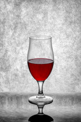 A glass of red wine on a gray background