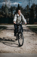 Carefree young girl cycling down a scenic path in the park, embodying the joy of a relaxed weekend outdoors.