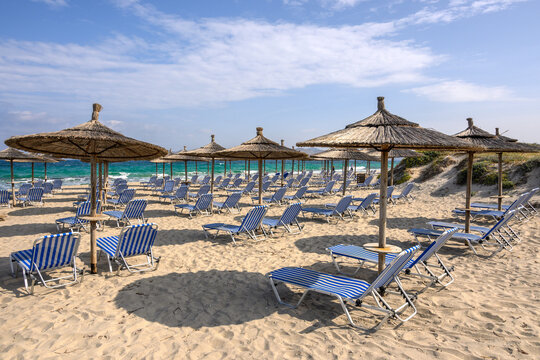 Sun loungers on the Marmari beach on the island of Kos. Beautiful sandy beach with turquoise waters. Greece