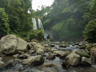 A man explores the tropical rainforests to find a waterfall