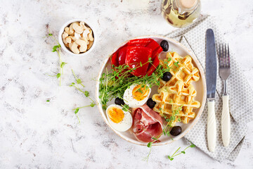 English breakfast. Boiled egg, jamon, waffles and green herbs. Top view, flat lay - 779142327
