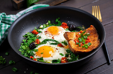 Keto breakfast. Fried eggs  with spinach and toast. - 779142706