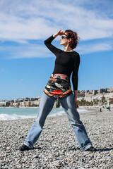 Beautiful girl with a silk scarf on the beach in Nice
