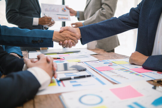 committee of businessmen and investors join hands as symbol of joint investment after discussing consulting and making contract  invest in business together. committee joins hands in meeting.