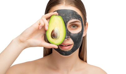 Beautiful smiling woman with clear skin holds a ripe avocado near her face. She applied the mask to her face. Cosmetological skin care