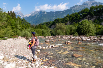 Woman with baby carrier with scenic view of Soca River, Bovec, Triglav National Park,Slovenia....