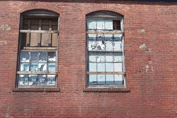 Abandoned brick industrial building with broken and weather worn windows