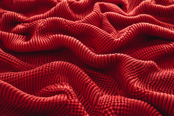 An expanse of red thermal knit fabric, illustrating the waffle-like texture that traps warmth, ideal for cozy, winter wear that combines comfort with practicality. 32k, full ultra HD, high resolution