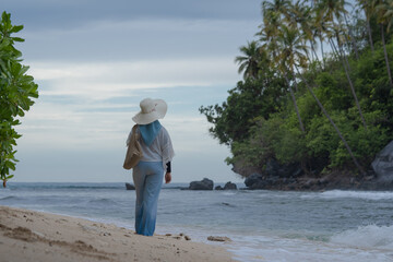 A woman walks alone on a beautiful beach