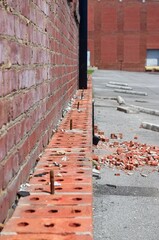 Brick ledge with debris and rusty bolts