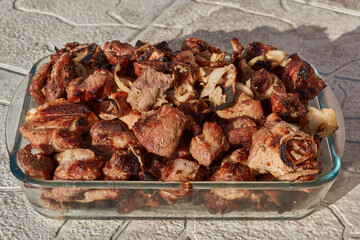 Barbecue from skewers removed in a glass form. Close-up.