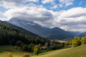 Fototapeta na wymiar Lush green alpine meadows and forest with scenic view of Karawanks mountain range in Carinthia, Austria. Remote villages on alpine landscape in Bodental, Austrian Alps. Wanderlust concept in spring