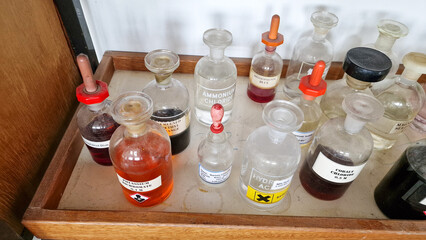 Educational chemistry chemical bottles on a wooden shelf