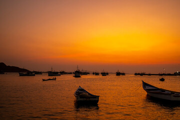 Naklejka premium Fishing boats during a beautiful and colorful sunset in Juan Griego beach, Margarita Island. Venezuela