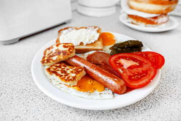Plate of food with eggs, sausage, tomatoes, and cheese
