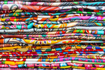 Stacked assortment of colorful fabric for sale