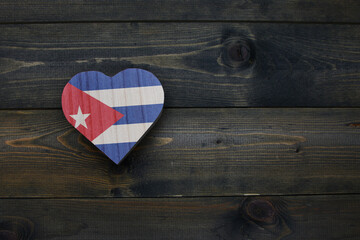 wooden heart with national flag of cuba on the wooden background.