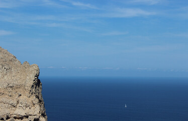Scenic view of a a small sailboat in the middle of the sea. Located in Cap Formentor, Majorca, Port de Pollenca, Serra de Tramuntana, Balearic Islands, Spain, Europe. 