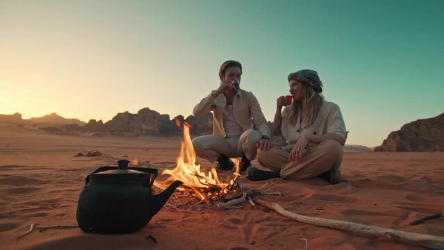 Travelers in Jordan Wadi Rum Sitting and drinking desert tea next to a camp fire