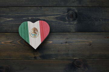 wooden heart with national flag of mexico on the wooden background.