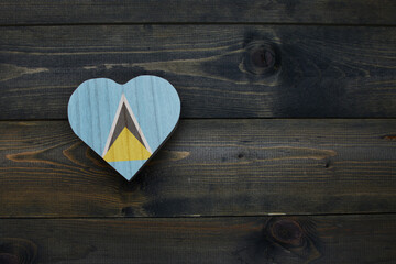 wooden heart with national flag of saint lucia on the wooden background.