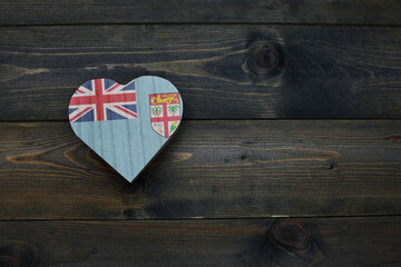 wooden heart with national flag of Fiji on the wooden background.