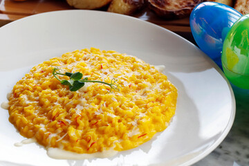 traditional italian food saffron risotto with parmesan cheese on an easter festive table