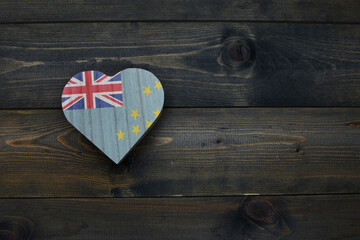 wooden heart with national flag of Tuvalu on the wooden background.