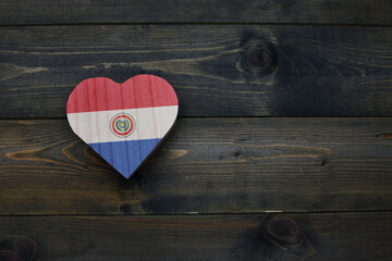 wooden heart with national flag of paraguay on the wooden background.