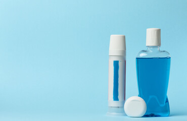 Mouthwash, toothpaste tube, dental floss on a blue background, oral hygien